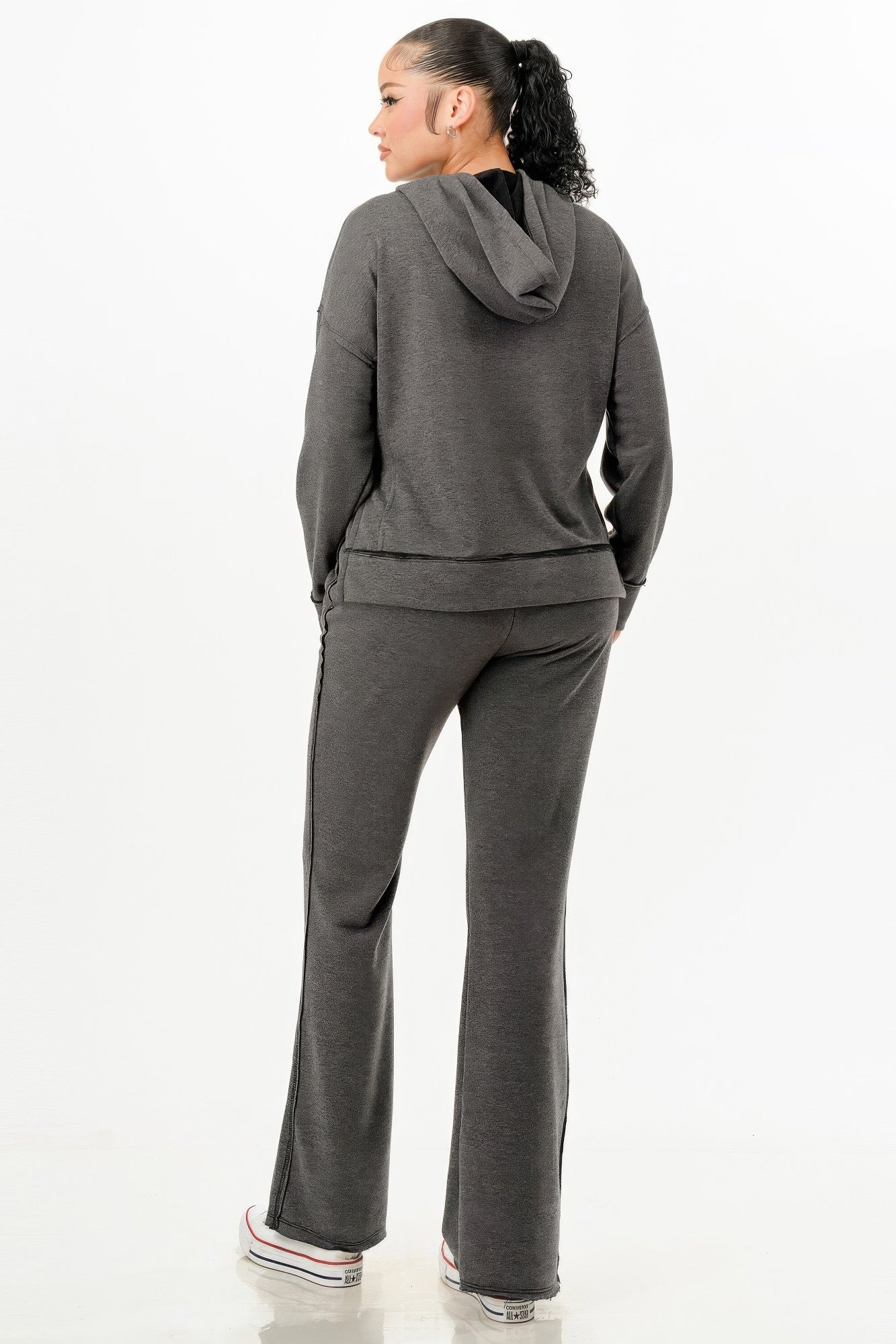 Back view of a woman wearing womens comfy travel tracksuit in dark gray with a hooded sweatshirt and matching pants