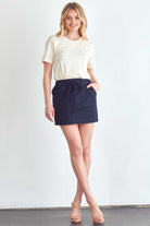 BLUME AND CO. women's drawstring skirt with pockets in navy worn with cream t-shirt and sandals