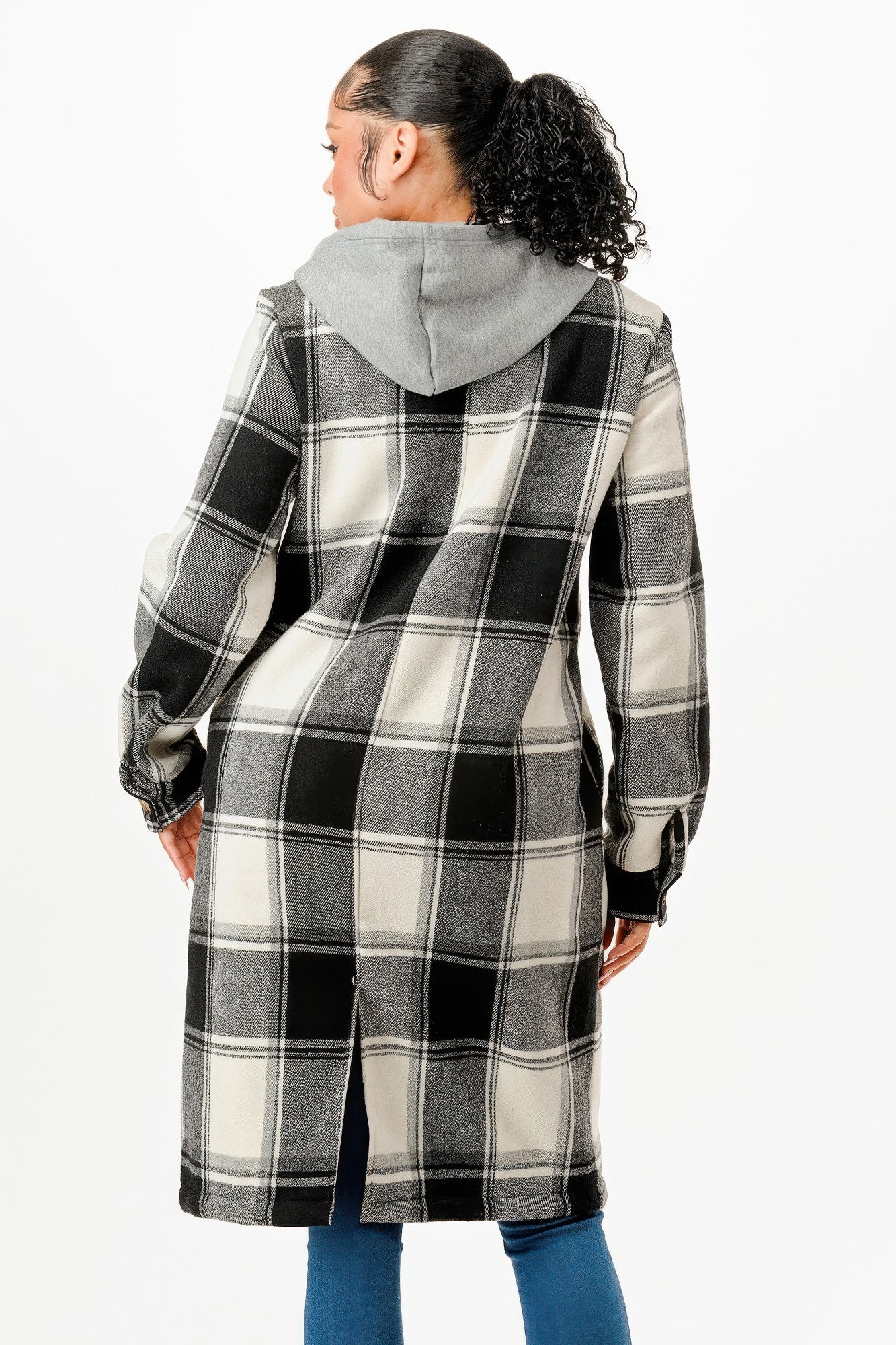 Back view of a women's hooded plaid coat in black and white with a gray hood and side slits