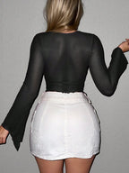 Back view of a woman wearing a black womens sexy navel exposed shirt paired with a white mini skirt