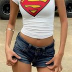 Women's white Superman crop top with blue denim shorts, trendy y2k fashion