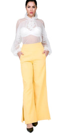 Yellow side slit trousers vacation style for women paired with sheer white blouse and black heels