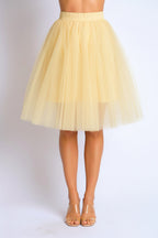 yellow  tulle skirt worn by a person on a plain background