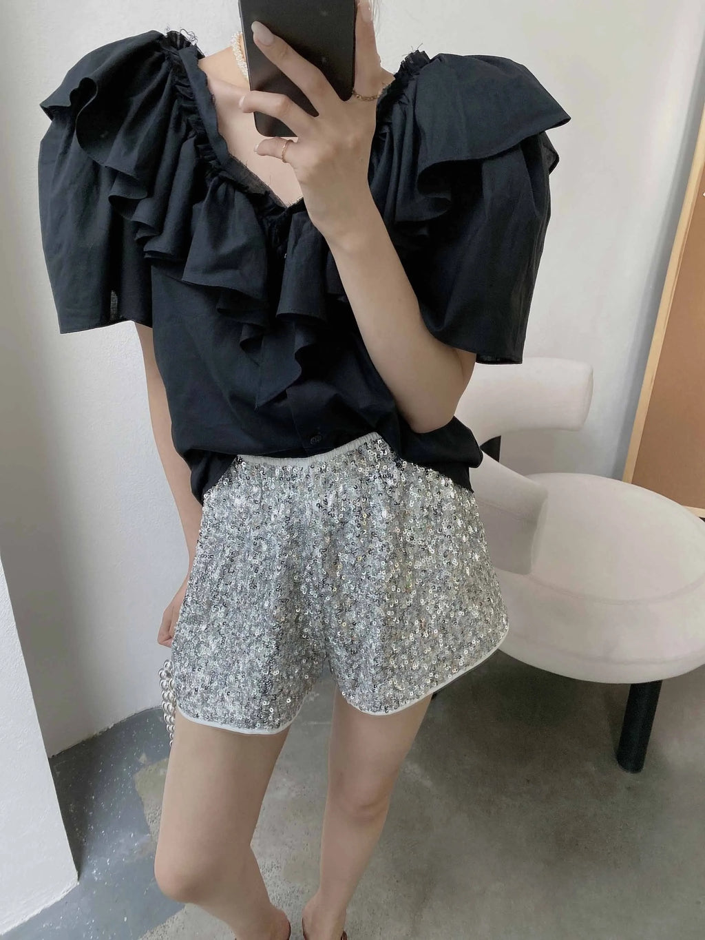 Black ruffled top and silver sequin shorts, vacation worthy outfit