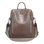 Brown leather travel bag with woven strap for versatile use