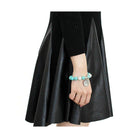 Antique silver women's bracelet featuring colorful beads, styled with a black dress.