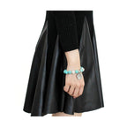 Antique silver women's bracelet featuring colorful beads, styled with a black dress.