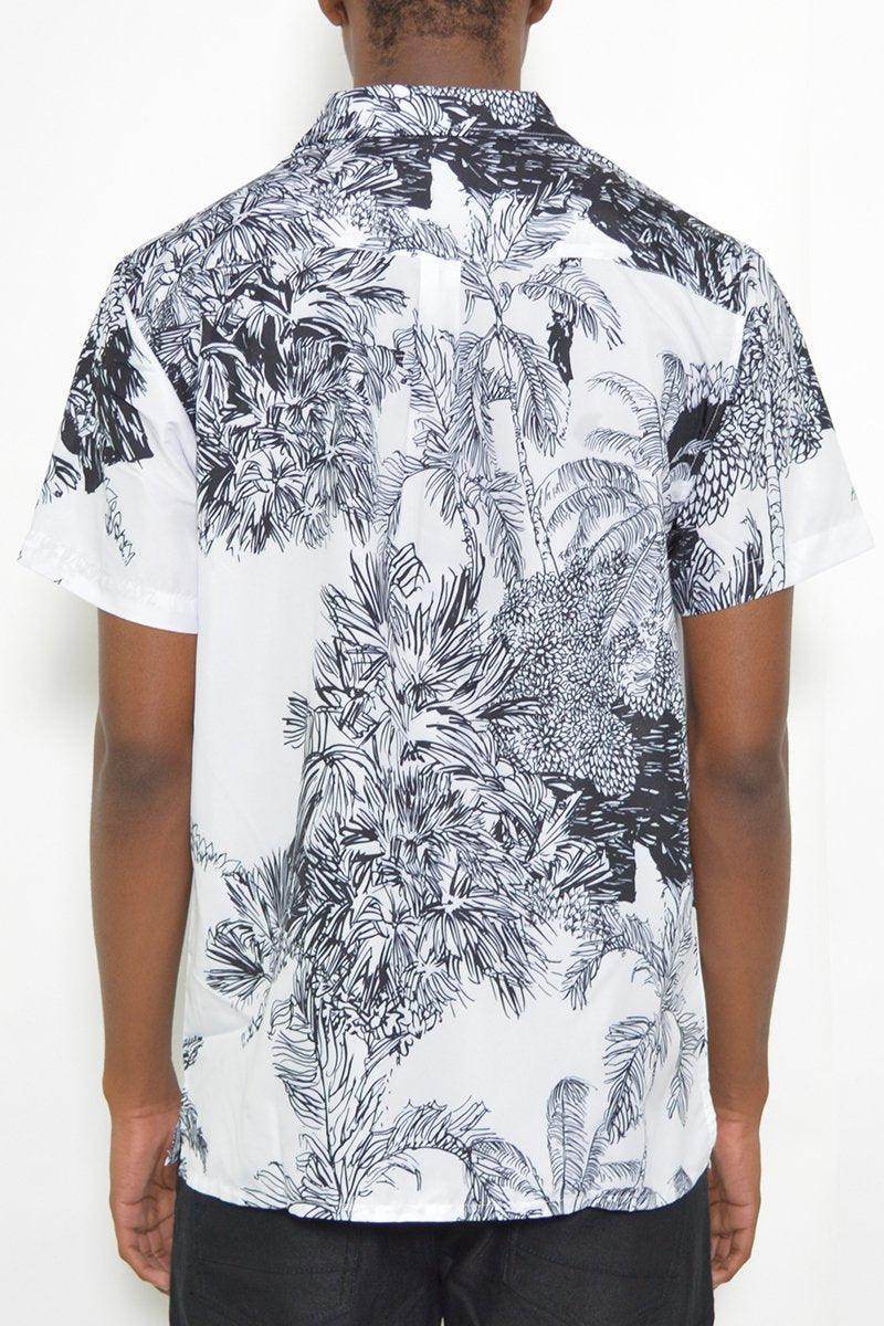 Back view of a black and white short sleeve shirt showcasing a tropical leaf print design