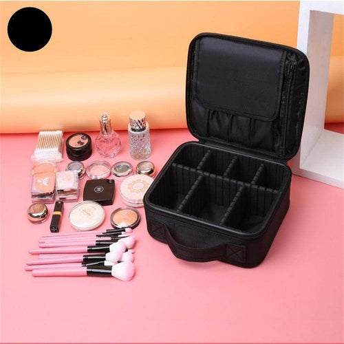 Portable makeup bag for trips in black, featuring multiple compartments and makeup tools arranged on a pink surface