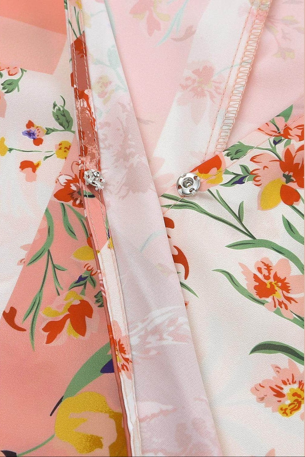 Close-up of VacationGrabs boho pink floral wrap shirt featuring vibrant floral patterns and button detail