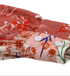 Close-up of a boho pink floral wrap shirt showcasing floral patterns and button details