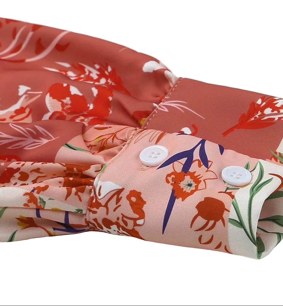Close-up of a boho pink floral wrap shirt showcasing floral patterns and button details