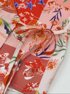 Boho pink floral wrap shirt featuring colorful floral patterns and a stylish tie detail for women