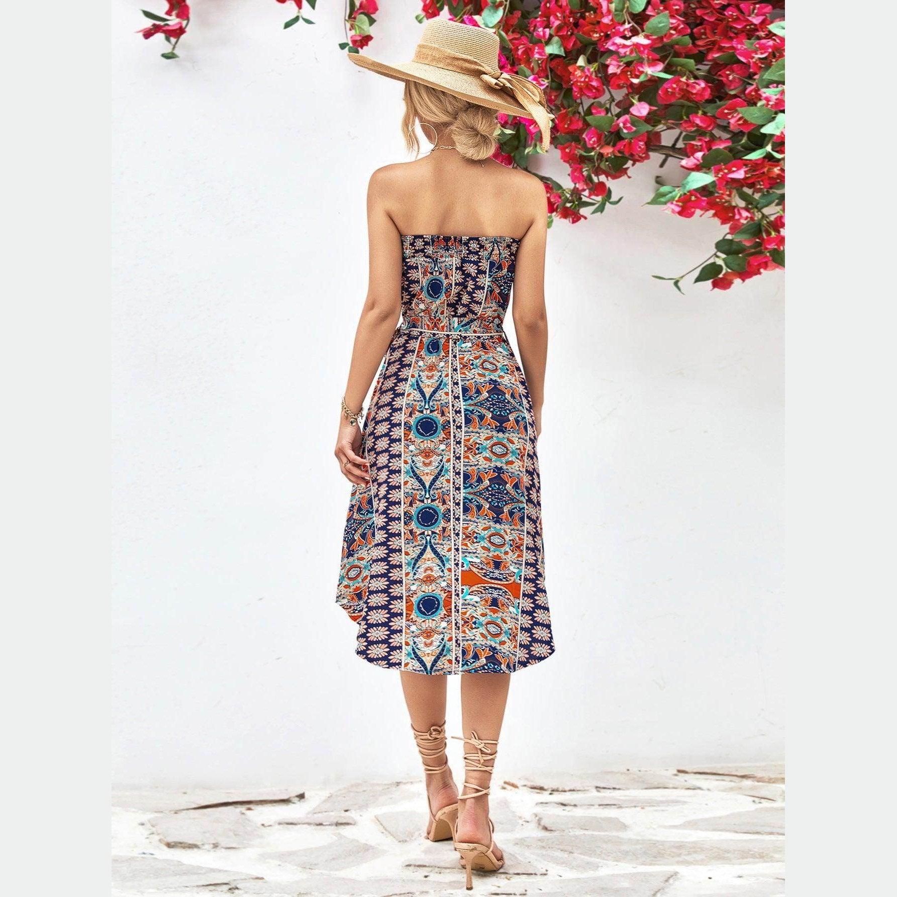 Back view of a woman's boho style strapless dress with colorful floral patterns and mid-length skirt