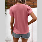 Back view of a pink casual v-neck vacation shirt for women, styled with denim shorts