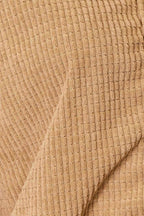 Close-up of a textured beige women's casual vacation jacket featuring a soft ribbed design