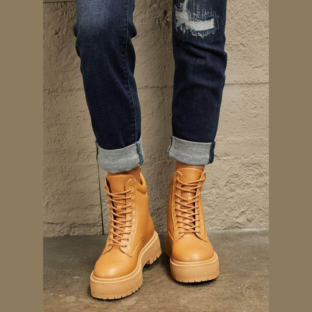 Women's tan combat boots with sturdy laces and chunky soles