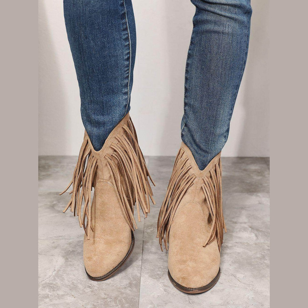 Women's tan cowboy boots with fringe detail for western style