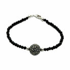 Stylish black beaded bracelet with a decorative centerpiece, ideal for an elegant brass bracelet for vacation outfits