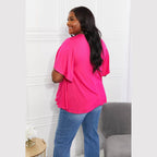 Back view of a woman wearing an elegant pink top paired with blue jeans for a stylish look