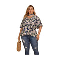 Plus size women's flutter sleeve floral top in navy with white flowers, styled with jeans and a handbag
