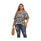 Plus size women's flutter sleeve floral top in navy with white flowers, styled with jeans and a handbag
