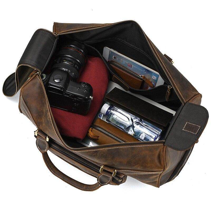 Genuine leather luggage bag filled with a camera, wallet, and other travel essentials