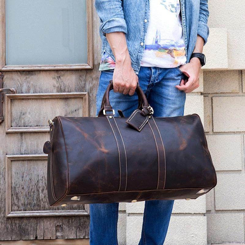 Genuine leather weekender bag held by a person in casual attire for stylish travel