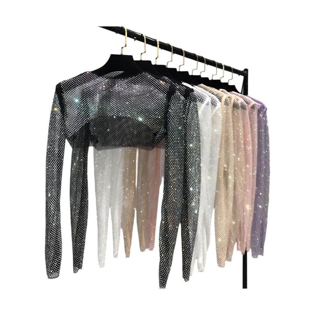 Variety of Women's Clubwear featuring glitter crop tops in multiple colors hanging on a rack