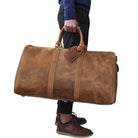 Large leather weekend bag in rustic brown held by a person, perfect for travel and stylish getaways