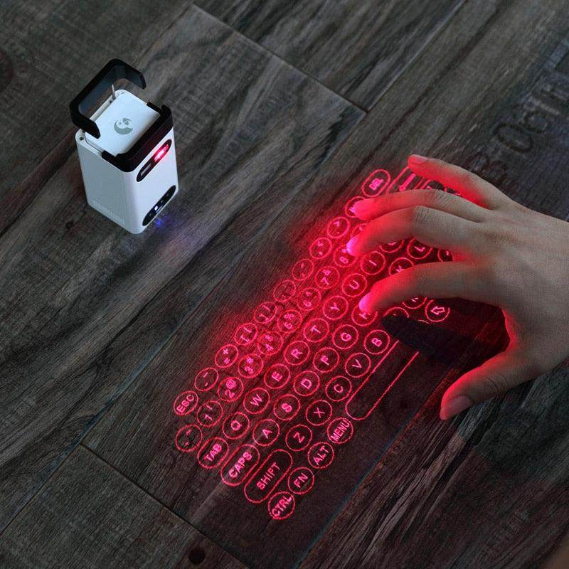 Hand using a mobile compatible keyboard projected on a wooden surface with a portable gadget beside it