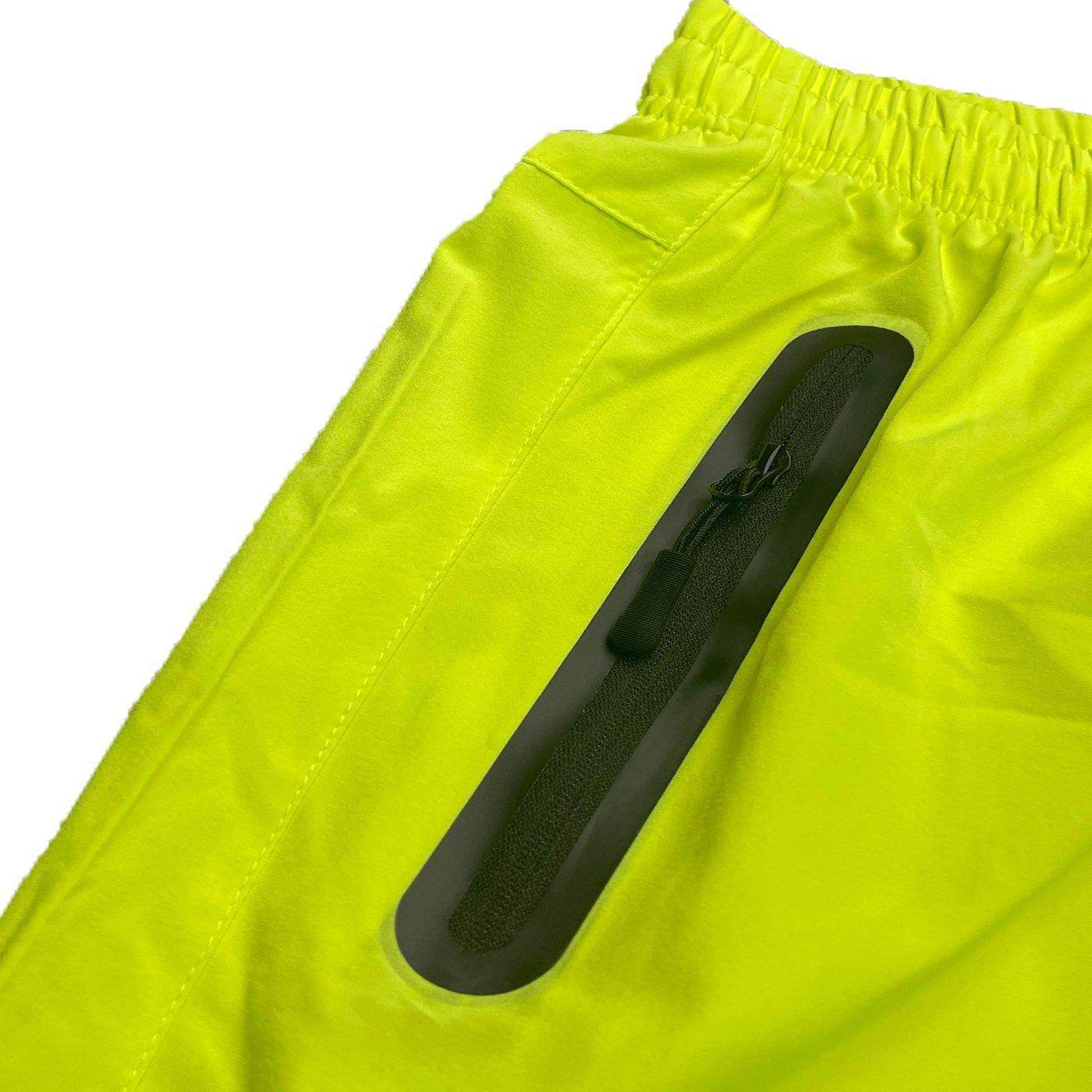Close-up of VacationGrabs neon yellow running shorts featuring a secure zip pocket