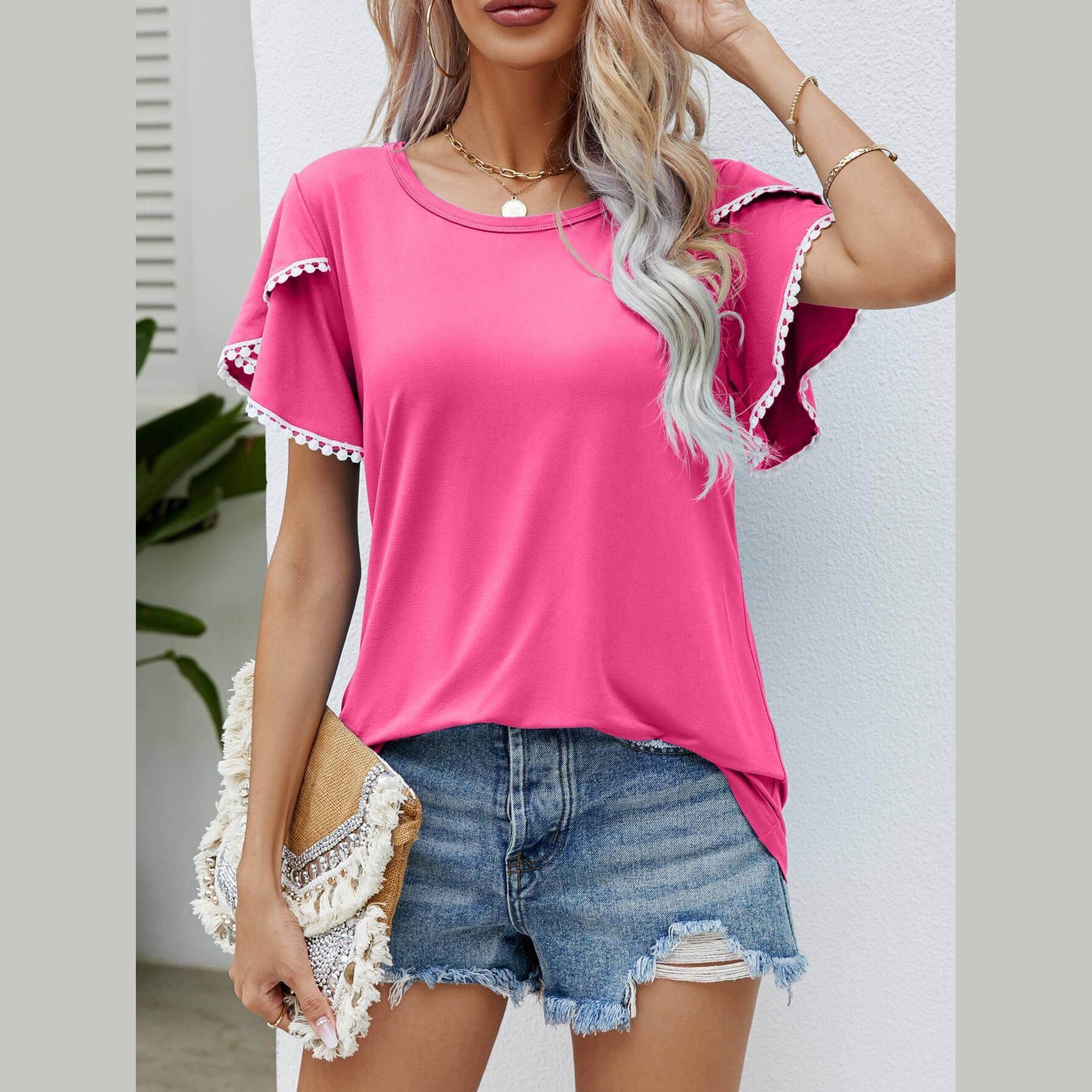 Trendsi Women's Pom-Pom Flutter Sleeve Tee in Pink, styled with distressed denim shorts
