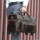 Premium leather wheeled duffel bag in dark brown with sturdy handles and zippered pockets