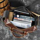 Open premium leather wheeled duffel bag showing organized travel items and accessories inside