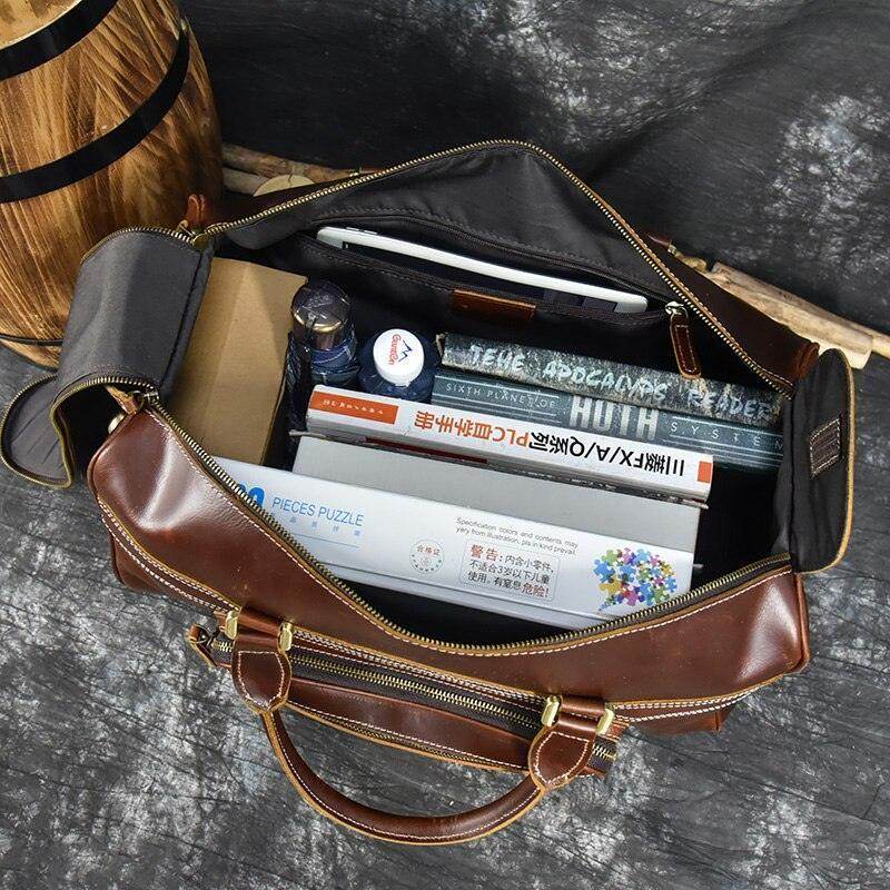 Open premium leather wheeled duffel bag showing organized travel items and accessories inside