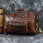Premium leather wheeled duffel bag in brown with sturdy handles and zipper pockets