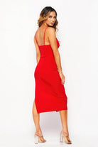 Back view of a woman wearing a red side slit summer dress with thin straps and a sleek fit