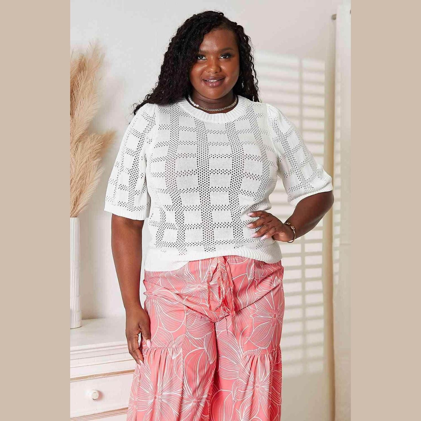 Stylish women's round neck knit top in white with perforated design, paired with pink floral pants