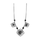 VacationGrabs ruthenium white metal necklace featuring decorative wire cage design and black accents