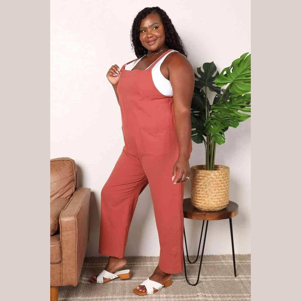 Plus-size woman wearing stylish vacation overalls in rust color with a comfortable fit for summer outings