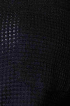 Close-up of a textured fabric in a black stylish vacation sweater by Trendsi