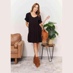 Trendsi black tiered summer dress with short sleeves, paired with a stylish fringe handbag and ankle boots