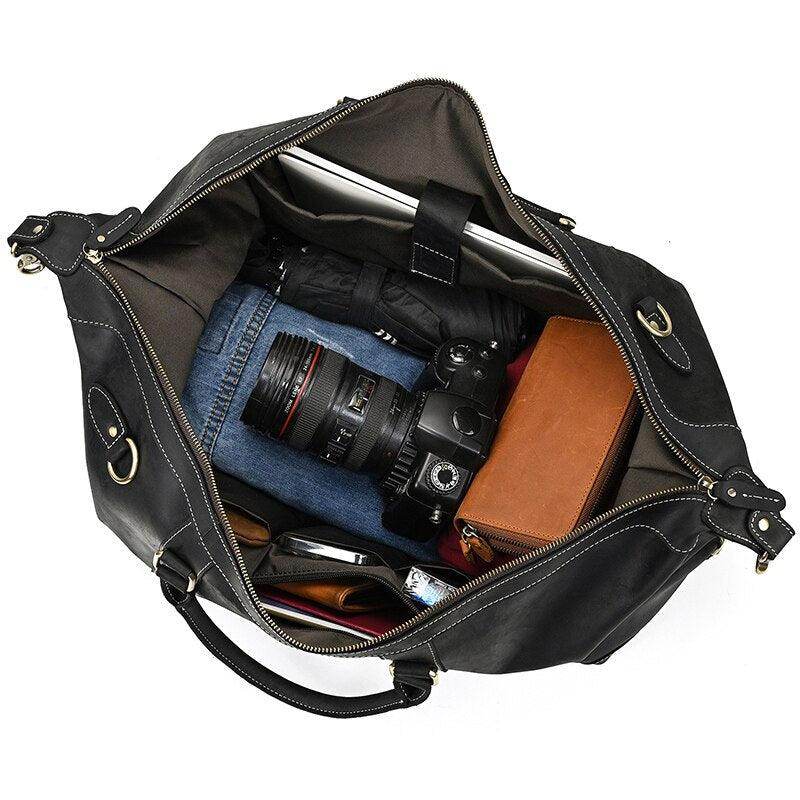Spacious vacation style leather bag with camera and clothing inside for travel enthusiasts