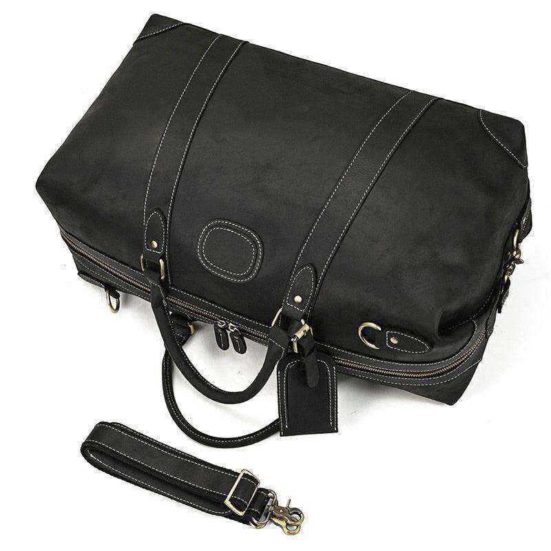 Vacation style leather bag in black with sturdy handles and detachable shoulder strap for travel convenience